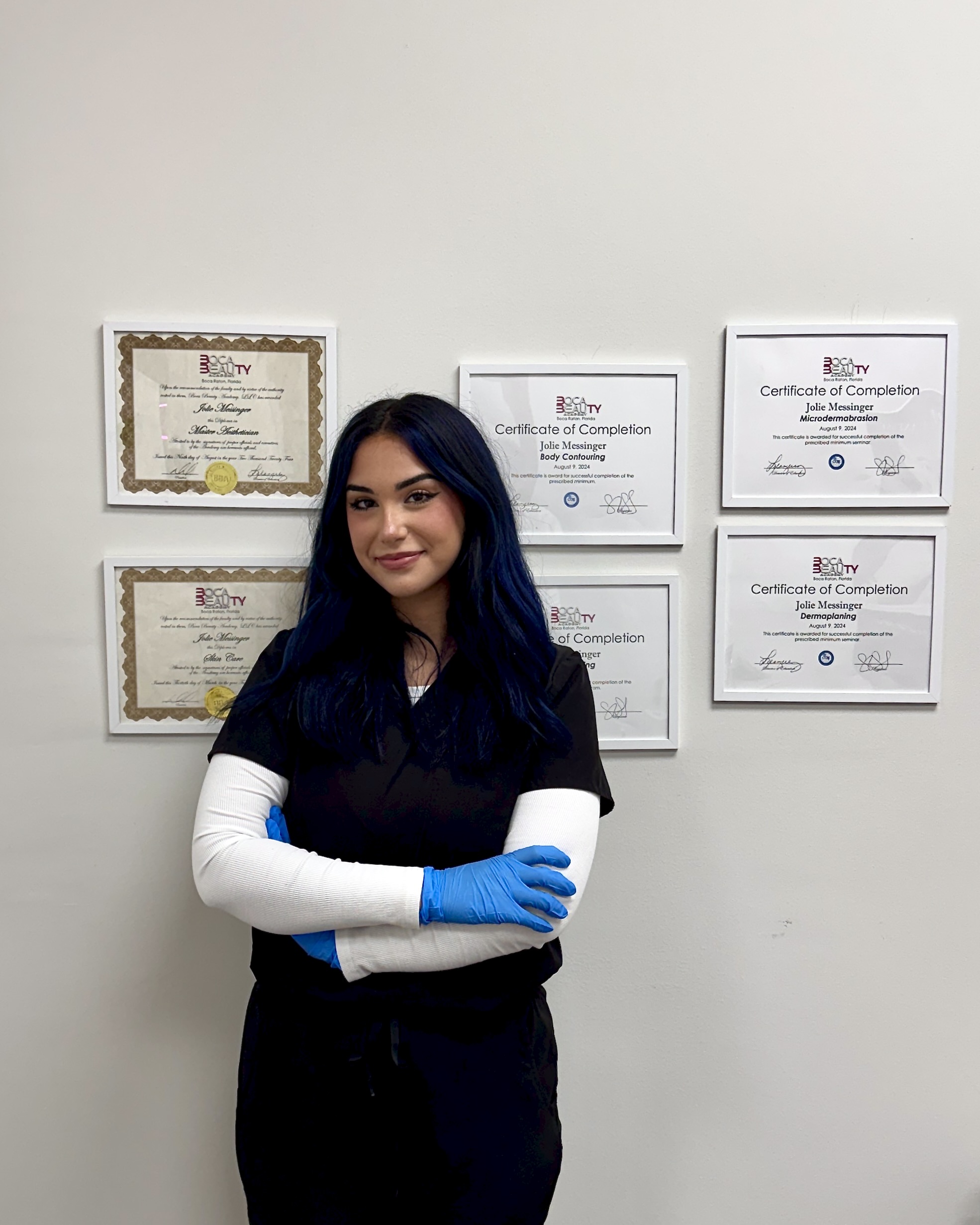 Jolie Messinger, master esthetician at The Ginger Injector, Boca Raton, in front of her training certificates
